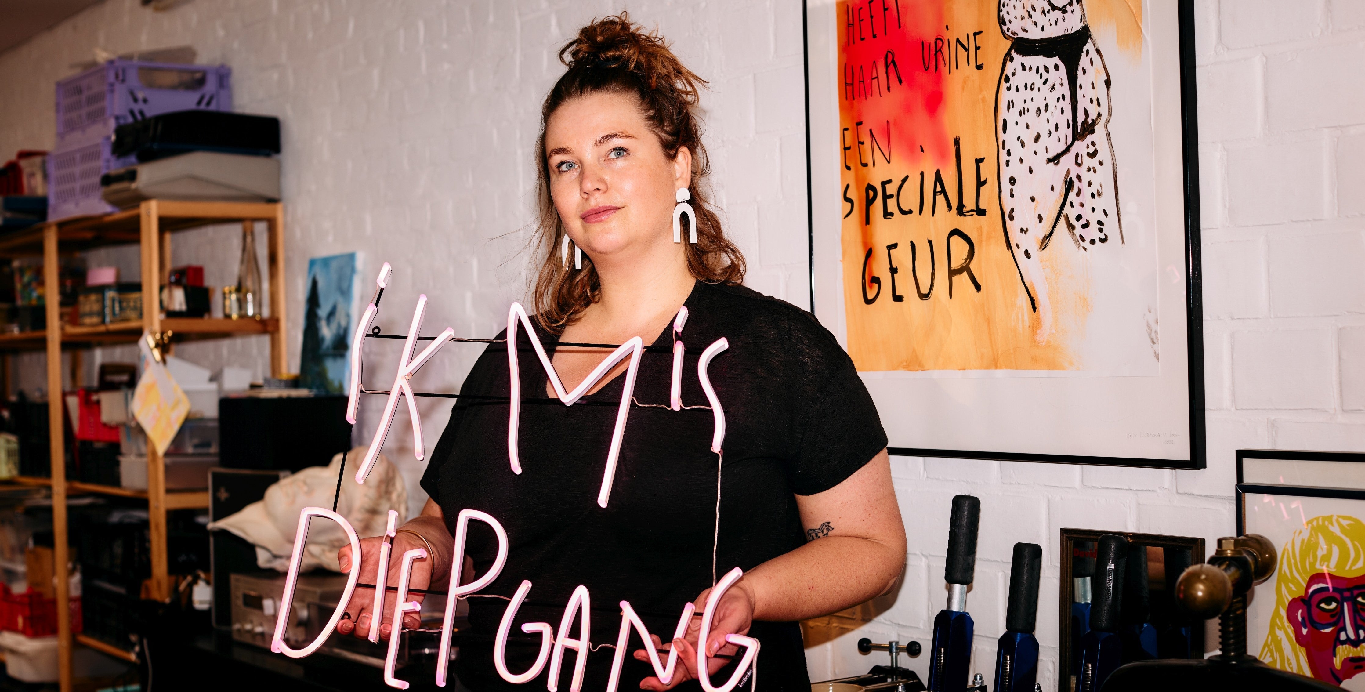 Kelly Hortense holding a LED Neon with the text "ik mis diepgang"